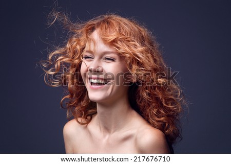 Close up portrait of an attractive young woman laughing with hair blowing