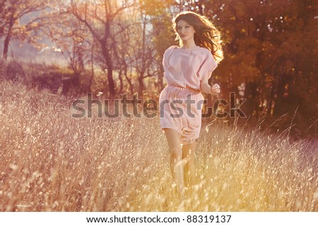 Beautiful woman in dress runing in the autumn forest