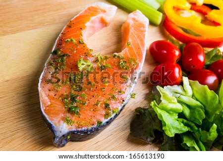Raw fresh Salmon steak on wood  cutting board  with vegetables