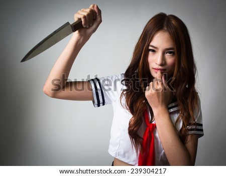 young woman in japanese anime cosplay holding knife, japanese school uniform.