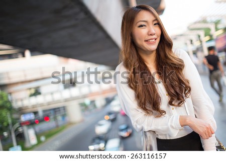 Portrait of asian woman in the city, smiling at outdoor in evening with city background