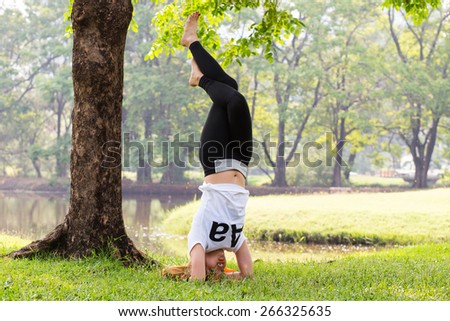 Young asian woman doing yoga in the  green natural park