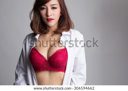 Sexy asian woman showing her sexy breast in red bra or  lingerie with shirt opened by her hand