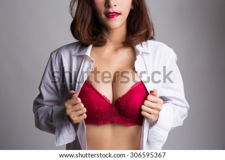 Sexy asian woman showing her sexy breast in red bra or  lingerie with shirt opened by her hand