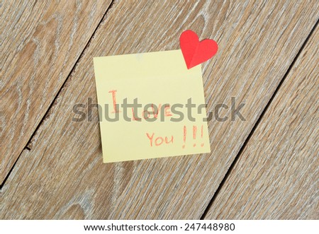 Valentine\'s Day sticker with a heart and a notebook on a wooden background