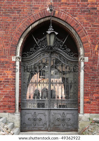 Gate in brick wall with wrought cast iron gates in Old Town, Riga, Latvia