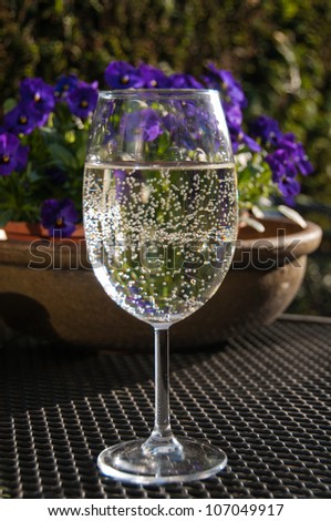 Glass of sparkling white wine on a terrace in the evening sun