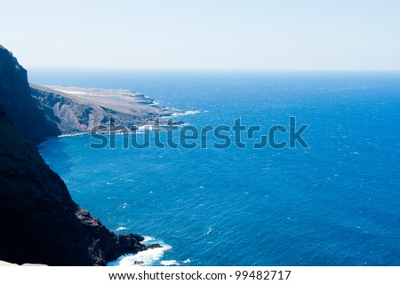 Mountains of lava with windmills  ending in the Atlantic Ocean