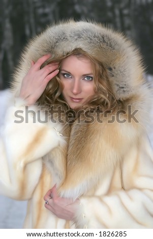 Portrait of the beautiful woman in the fur coat of the fox and mink