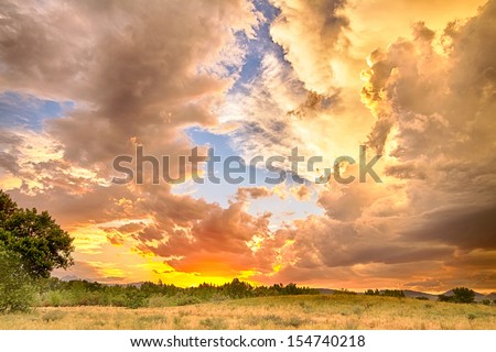 A beautiful epic sunset with blue sky behind the colorful majestic clouds. A scenic country landscape view looking west to the Colorado Rocky Mountains in Boulder County where the sky meets the land.