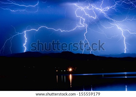 Lightning striking over McIntosh Lake in Longmont Colorado, Boulder County, hitting the foothills of the Front Range of the Rocky Mountains.