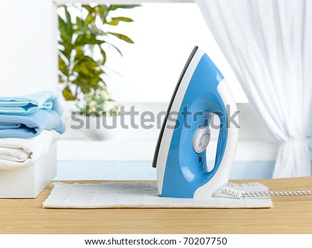 Modern steam iron on the the table in laundry room