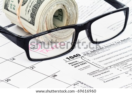 refund money on 1040 tax form with reading glasses
