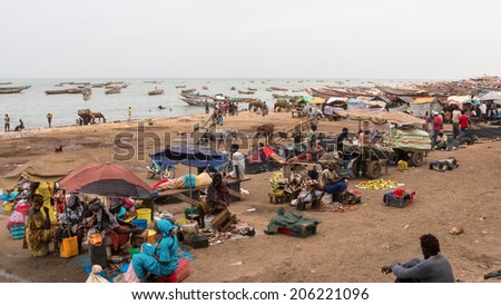 Mbour, Senegal - July 9, 2014: Several hundred people come together at the local fish market in Mbour to buy and sell the daily catch from the fishermen on July 9, 2014 in Mbour, Senegal.