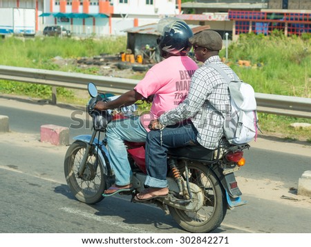 Cotonou, Benin: May 26: A man rides a hired Motorcycle taxi, the most common means of hired transportation in the city, on May 26, 2015 in Cotonou, Benin.
