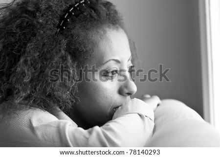 Nostalgic Ethiopian woman looking out the window in deep thought