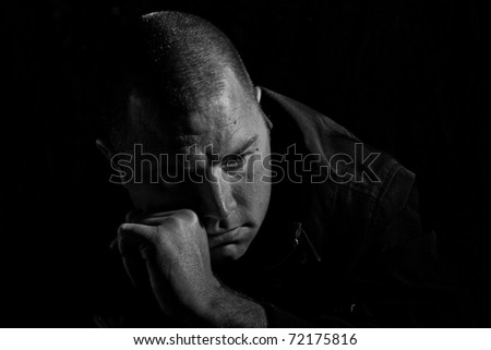 A man sitting down thinking with his hand on his face.  He could be thinking about a life changing decision, a choice he has made or he could be depressed.