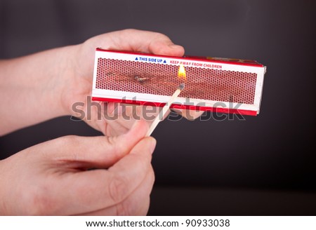 Image of hands lighting a match.