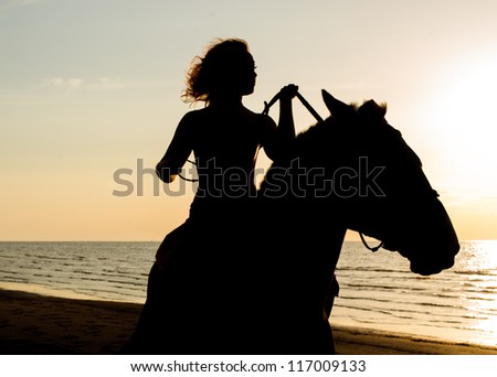 outline an unknown woman on a horse by the sea