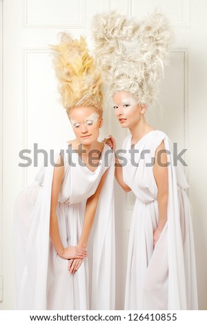Two blonds with an tall artistic hairdo