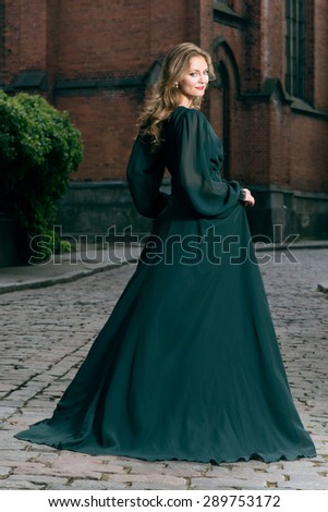 Beautiful luxurious woman in classic green dress