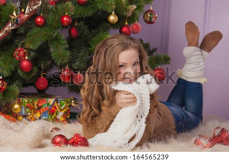 Beautiful girl hanging toy on Christmas tree