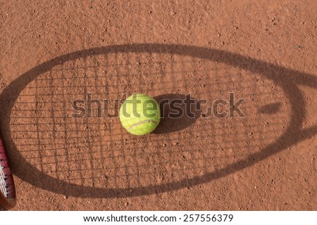 Close up view of tennis racket and balls on the clay tennis court
