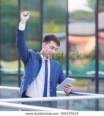 Dance success. Successful confident businessman celebrates his success. Young man formal wear his hands up and rejoice.