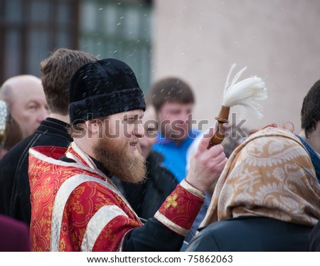 DONETSK, UKRAINE - APRIL 24: An unidentified  Orthodox priest spatter the holy water on Easter cakes at the celebration of Orthodox Easter at church on April 24, 2011 in Donetsk, Ukraine.