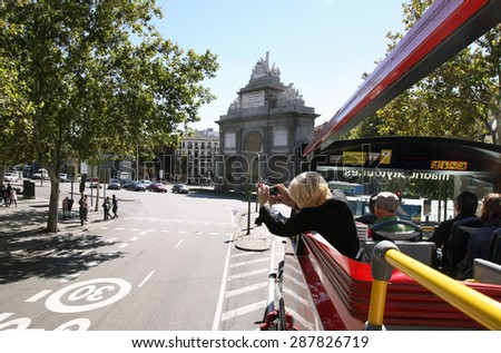 MADRID, SPAIN - OCTOBER 05, 2013: Woman photographed attractions from the sightseeing bus