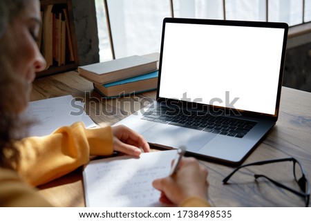 Hispanic teen girl, latin young woman school student elearning distance training course work at home office watching online learning webinar using laptop. Over shoulder close up mock up screen view.
