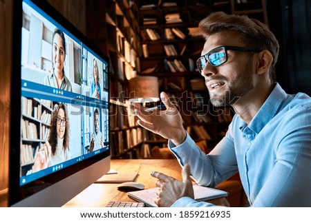 Young business man talking with diverse colleagues in virtual video conference group chat using computer at home office. Online professional videoconference communication, social distance work concept