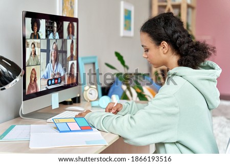African teenager high school student remote learning online group class at home. Mixed race teen girl distance studying during virtual class, group online lesson on video conference call with teacher.