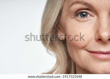 50s middle aged old woman looking at camera isolated on white background advertising dry skin care treatment anti age skincare beauty, plastic surgery, cosmetology procedures. Close up half face view Foto d'archivio © 
