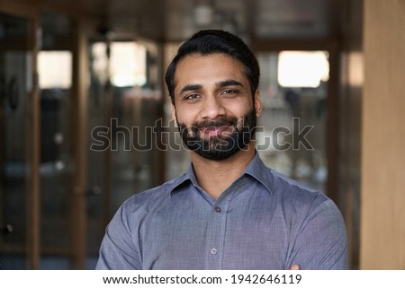 Portrait of young happy indian business man executive looking at camera. Eastern male professional teacher, smiling ethnic bearded entrepreneur or manager posing in office, close up face headshot.