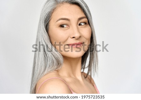 Middle aged happy mature asian woman, senior 50 year lady looking away, isolated on white closeup headshot. Ads of antiaging uv protection whitening menopause dry skincare, plastic surgery.