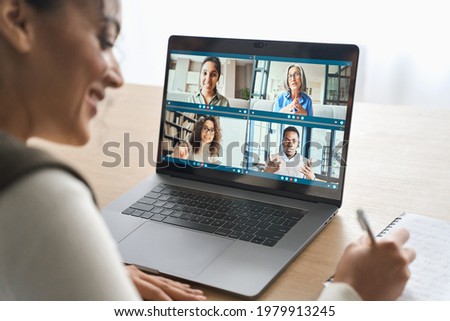 Happy smiling African American mixed race adult student having virtual meeting with diverse people online call elearning webinar at home office writing notes. Video e learning conference call on pc.