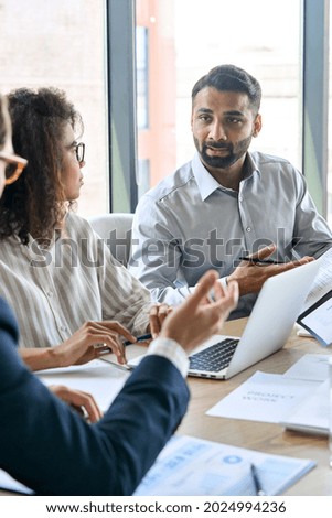 Diverse executive business team group discuss project at boardroom meeting table. Multiracial team negotiating developing international corporation business plan doing analysis in office. Vertical.
