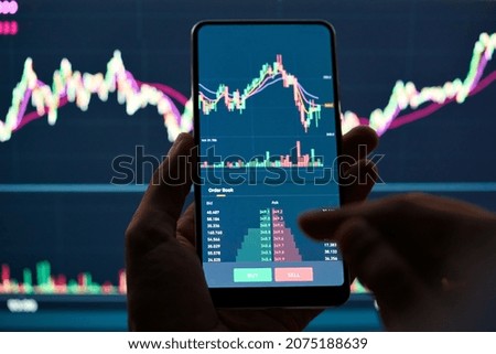 Crypto trader investor broker holding finger using cell phone app executing financial stock trade market trading order to buy or sell cryptocurrency shares thinking of investment risks profit concept. Stockfoto © 