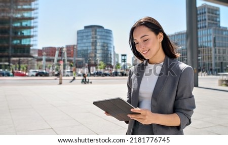 Similar – Image, Stock Photo Young Chinese woman looking at camera with serious expression in a modern office building