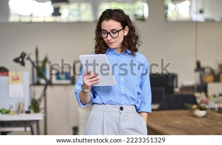 Similar – Image, Stock Photo Focused professional using app on tablet outside. Young African American business woman holding digital device, looking at screen, smiling. Online app concept, businesspeople,break from meeting