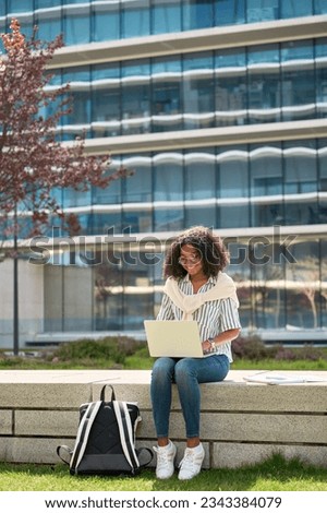 Similar – Foto Bild Student mit Rucksack beim Tippen auf Laptop und Notizblock im Park an hellem Tag