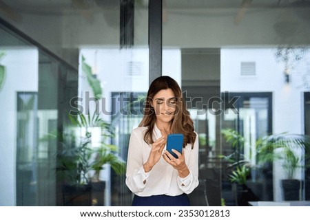 Similar – Foto Bild Elegante ethnische Geschäftsfrau zu Fuß in der Innenstadt mit Tasse Kaffee