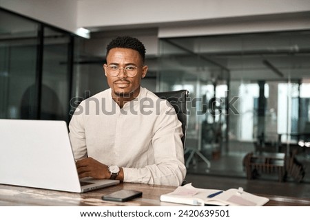 Similar – Image, Stock Photo Young afro American black man wearing a white sweatshirt and headphones seated on a blue wall looking to the side. Modern look