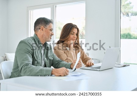 Similar – Image, Stock Photo Couple looking at laptop in kitchen.