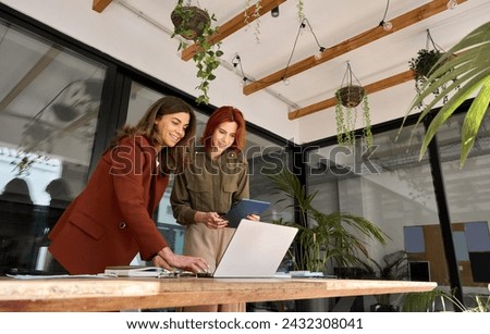 Similar – Image, Stock Photo Woman entrepreneur discussing financial data with her colleague standing at desk in office. Happy positive businesswoman working with charts and tables on computer. Two people working together