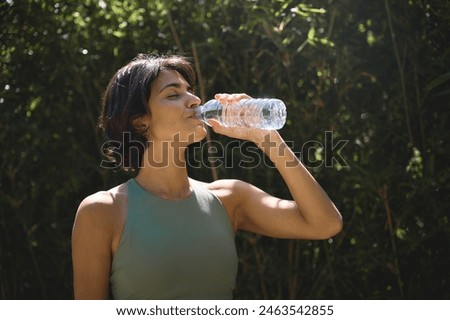 Similar – Image, Stock Photo Young woman drinking water while training on mat at home