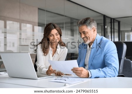 Similar – Image, Stock Photo Woman entrepreneur discussing financial data with her colleague standing at desk in office. Happy positive businesswoman working with charts and tables on computer. Two people working together