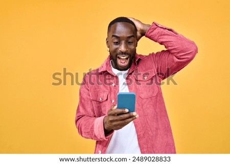 Similar – Image, Stock Photo Young black man holding wireless headphones while wearing a white sweatshirt, against a blue wall looking away with confidence. Selective focus