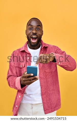 Similar – Image, Stock Photo Young african American black man combing his afro hair while seated on a yellow wall background, wearing a white sweatshirt and headphones. Looking to the camera with serious expression. Copy space